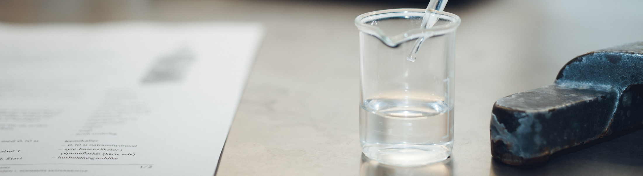 Foto af glas med væske og en pipette i.