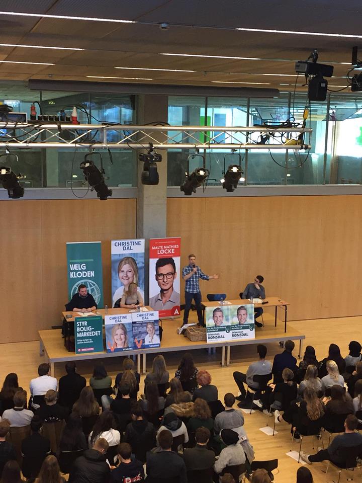 Foto af politikerpanel siddende i skolens aula.